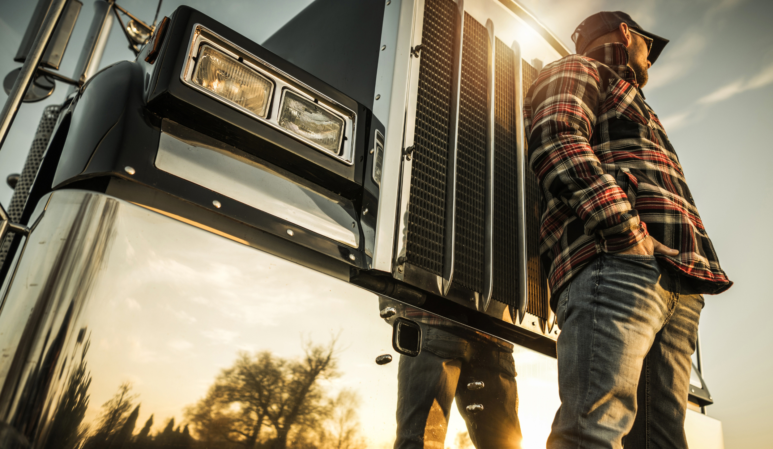 A truck driver with his semi waits for his next load because of deadheading.