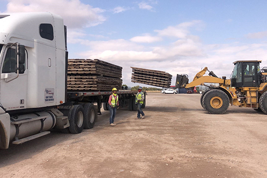 Flatbed trailer transporting structural and construction materials for a commercial freight shipment.