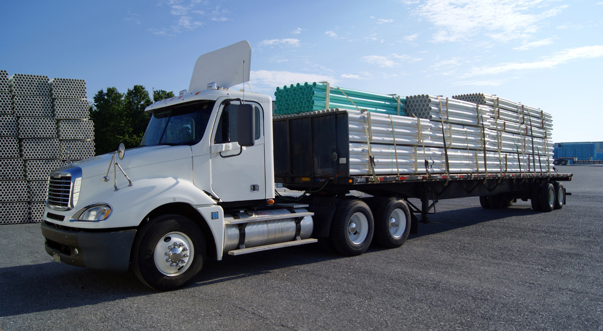 Buchanan Logistics Day Cab delivering a load of freight on a flatbed trailer via a Buchanan truck driver.