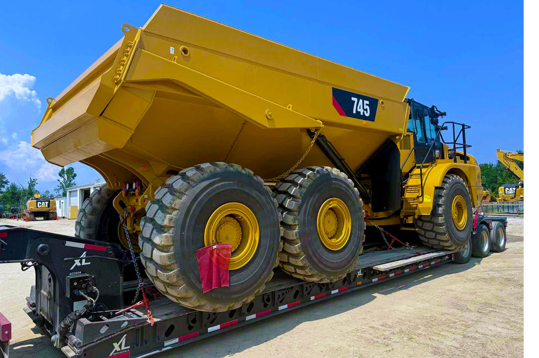 Buchanan Logistics uses their heavy haul trailer to transport a dump truck, construction equipment and materials to a jobsite.