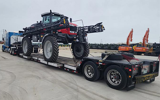 Buchanan Logistics hauling agricultural equipment with a double-drop flatbed trailer