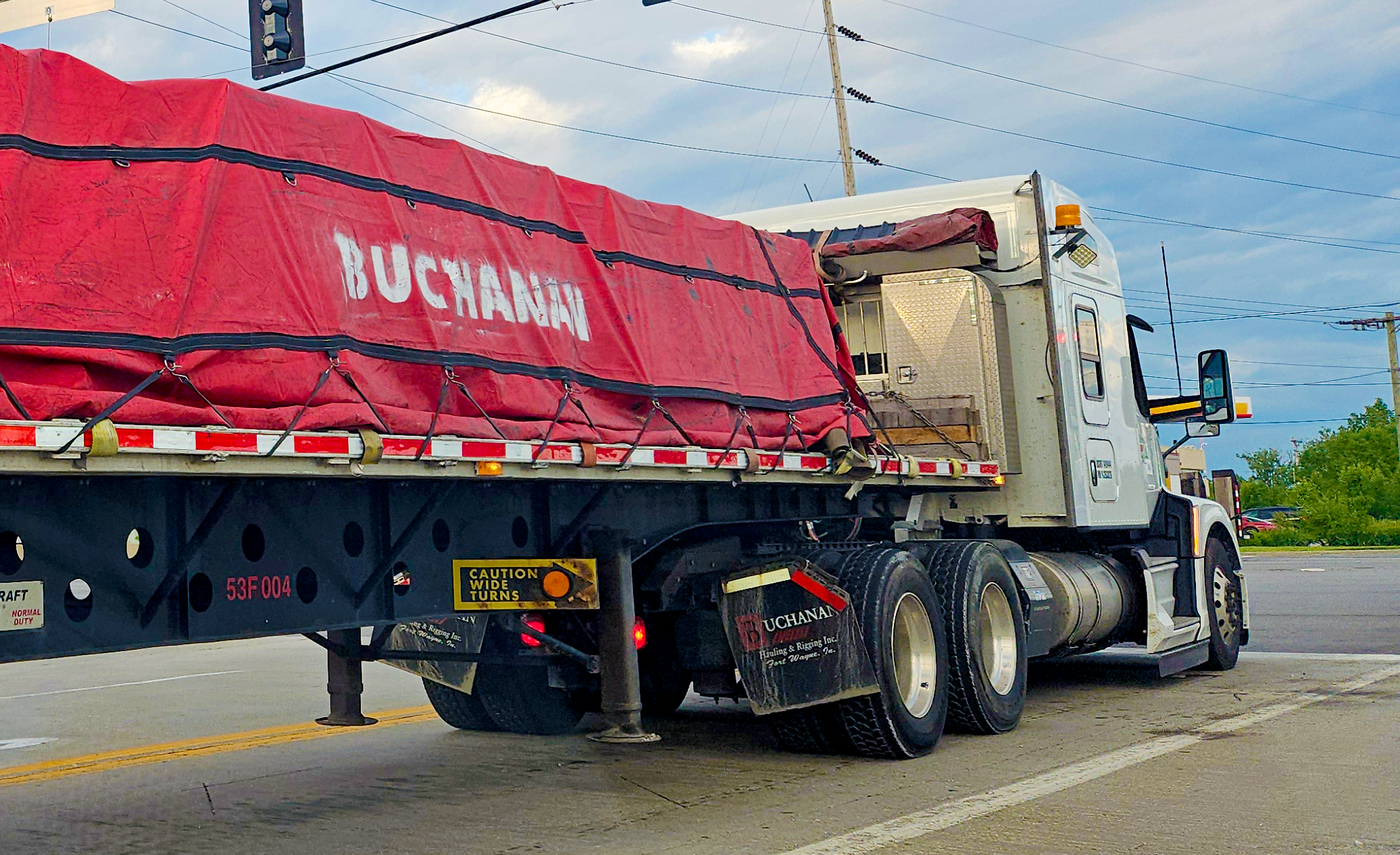 Retail freight bound on the back of a flatbed trailer and tarped by Buchanan Logistics.