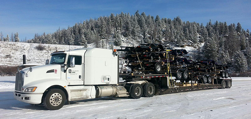 Buchanan Logistics truck moving automotive freight on the back of their step deck trailer.