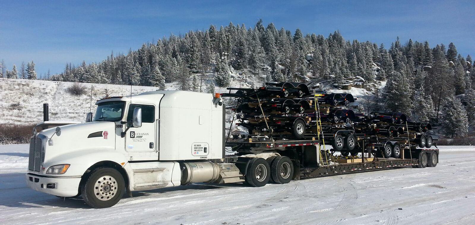 Buchanan Logistics truck moving automotive freight on the back of their step deck trailer.
