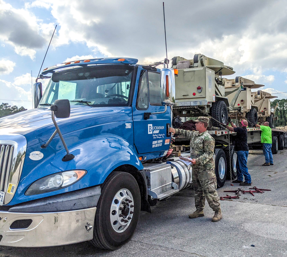 Military vehicles being loaded onto a Buchanan Hauling truck for transport.